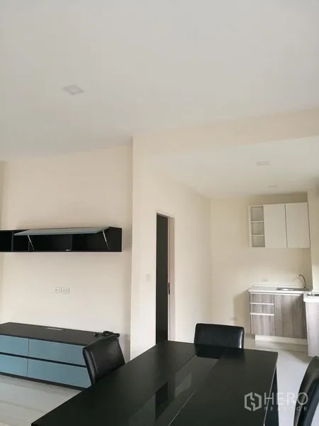 Townhouse for rent in Saphan Sung, Bangkok - Dining area beside a compact pantry kitchen with cabinets and sink.