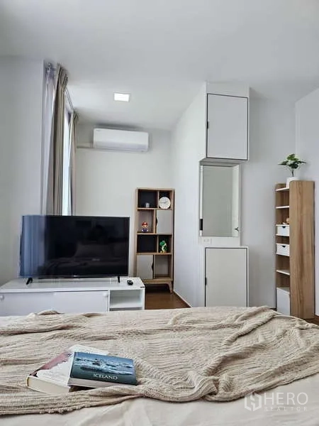 Townhouse for rent in Bang Phli, Samut Prakan - Master bedroom with TV unit, shelving and air conditioner.