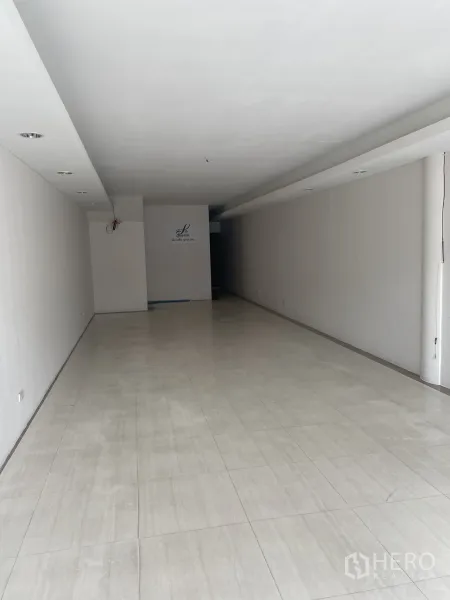 店屋 出租在Khlong Toei, Bangkok - 一层开放式零售空间，浅色地砖，进深长且通透。