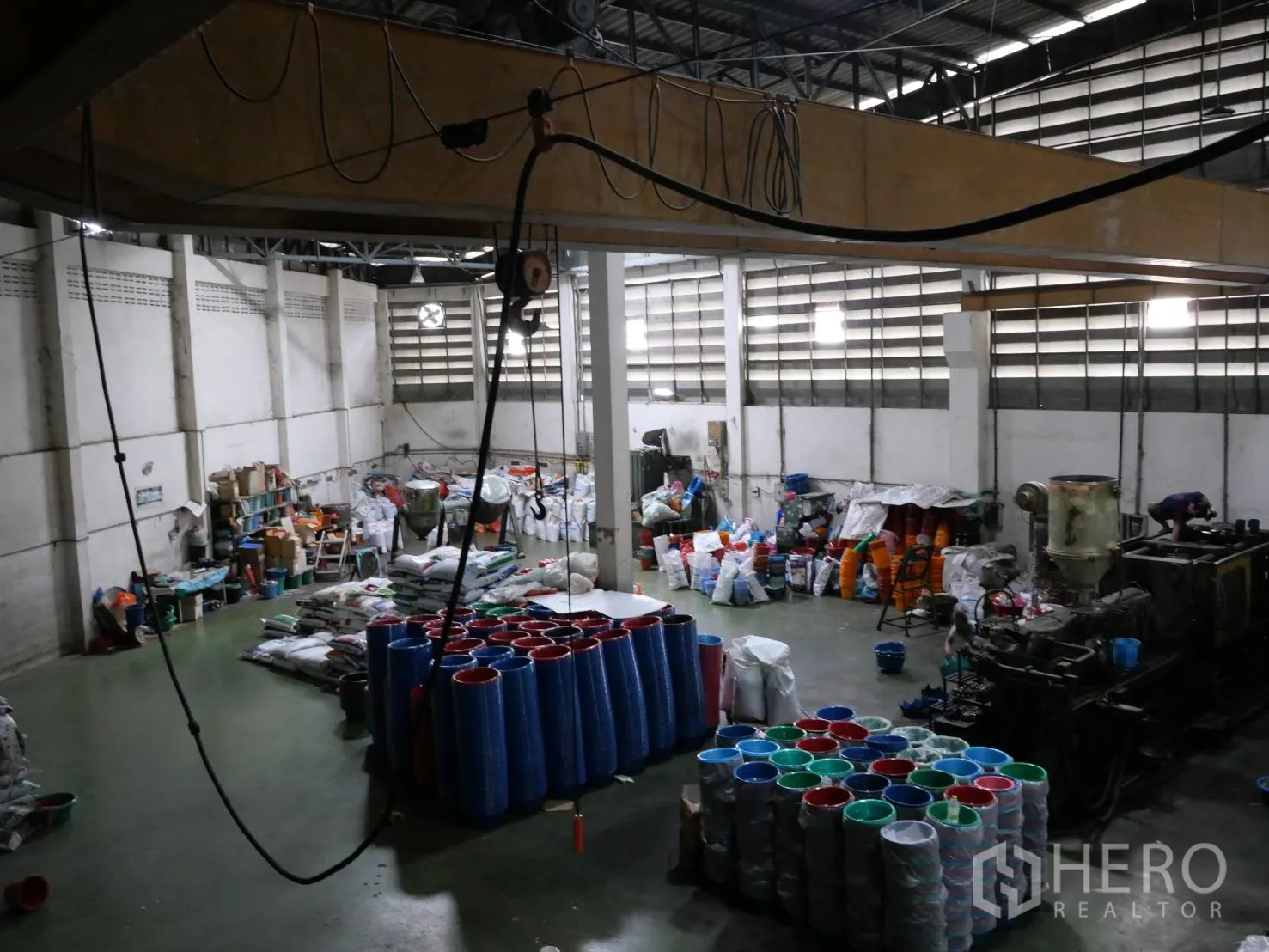 工厂 出租或出售在Bang Khun Thian, Bangkok - 生产车间，高挑屋顶，地面堆放塑料制品及天车线路。