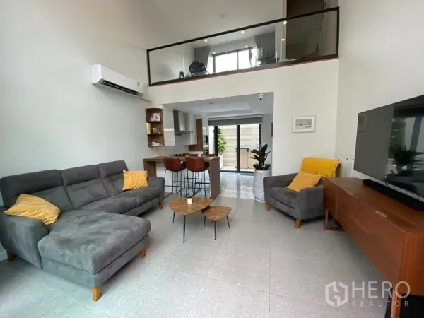 ทาวน์เฮาส์ ให้เช่าในSuan Luang, Bangkok - โถงนั่งเล่นเพดานสูงแบบดับเบิลวอลุ่ม โซฟาเซ็ต ทีวี และชั้นลอย