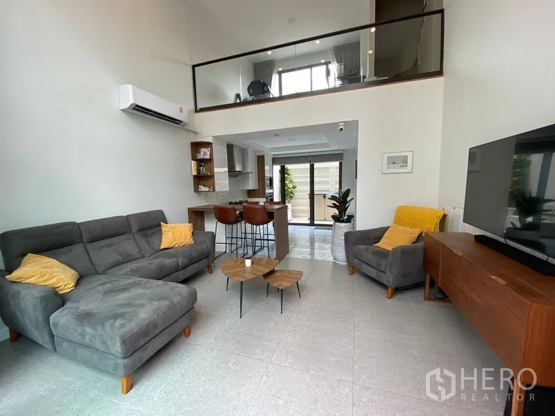 ทาวน์เฮาส์ ให้เช่าในSuan Luang, Bangkok - โถงนั่งเล่นเพดานสูงแบบดับเบิลวอลุ่ม โซฟาเซ็ต ทีวี และชั้นลอย