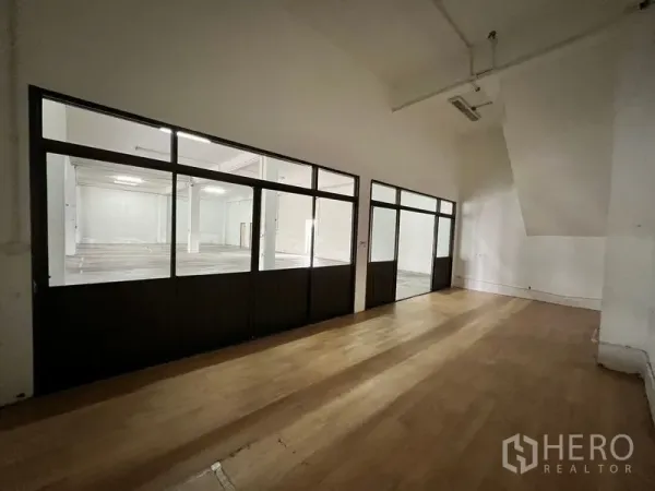 Warehouse for rent in Min Buri, Bangkok - Long glass‑walled office corridor overlooking the warehouse work area.