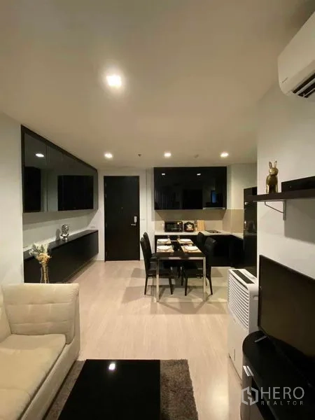 คอนโด ให้เช่าในKhlong Toei, Bangkok - พื้นที่นั่งเล่นและรับประทานอาหารแบบเปิด พร้อมตู้บิวท์อินสีดำ โต๊ะรับประทานอาหาร 4 ที่ และไฟดาวน์ไลท์