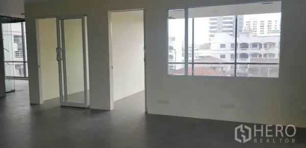 办公空间 出租在Suan Luang, Bangkok - 分隔式办公室，推拉玻璃门与大窗，外望社区建筑景观。