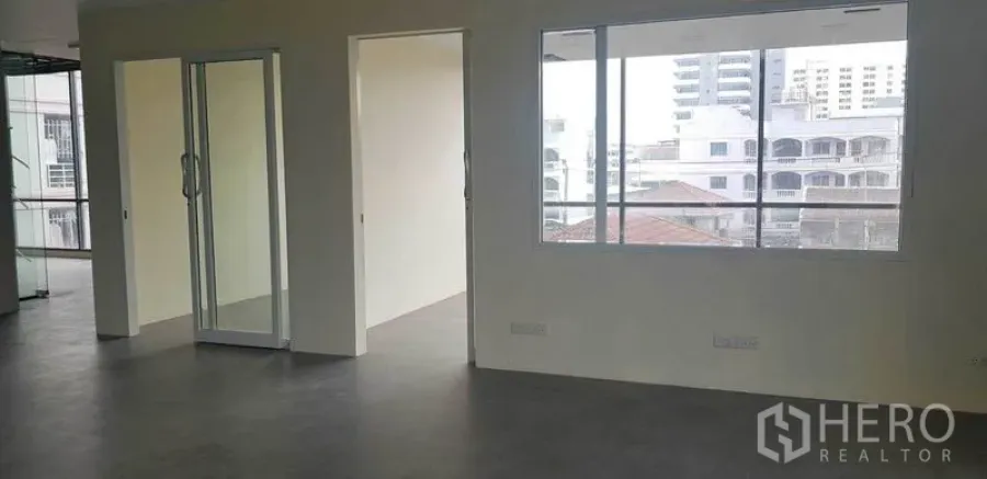 办公空间 出租在Suan Luang, Bangkok - 分隔式办公室，推拉玻璃门与大窗，外望社区建筑景观。