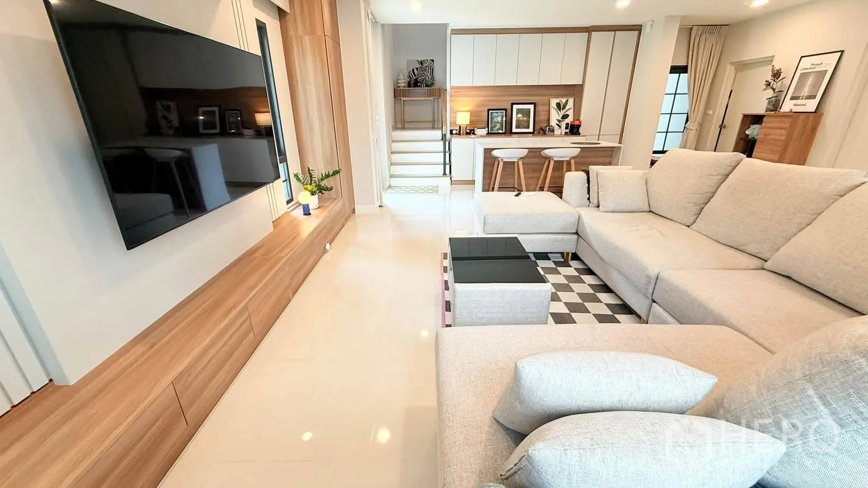 独栋房屋 for rent in Bang Phli, Samut Prakan - 客厅设大型转角沙发、墙挂电视与棋盘格茶几。
