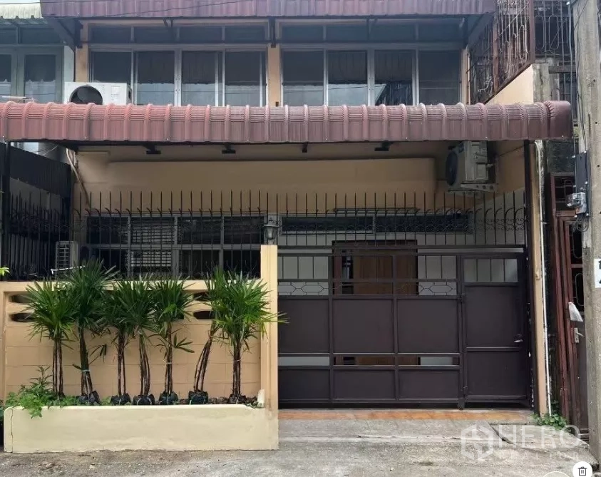 ทาวน์เฮาส์ ให้เช่า - ด้านหน้าทาวน์เฮ้าส์ 2 ชั้น พร้อมประตูเหล็ก กันสาด และแปลงต้นปาล์ม
