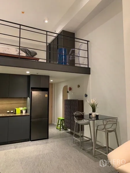 公寓 出租在Bang Rak, Bangkok - 开放式厨房，深色橱柜与夹层卧区。