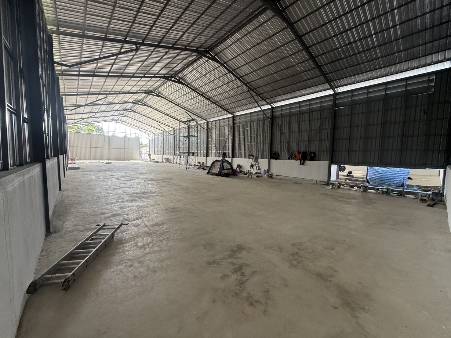 Warehouse for rent in Saphan Sung, Bangkok - Spacious warehouse interior showing high gable roof, steel trusses and smooth concrete floor in Saphan Sung, Bangkok.