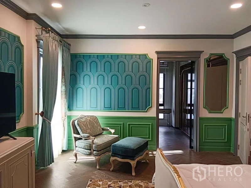 Detached House for rent or sale in Saphan Sung, Bangkok - Cozy sitting corner with classic armchair and green decorative wall panels.