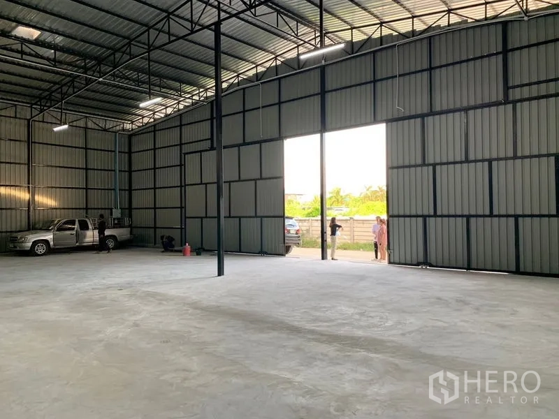 货栈 出租在Khan Na Yao, Bangkok - 从仓库内望向开启的推拉大门，装卸通道与自然采光。