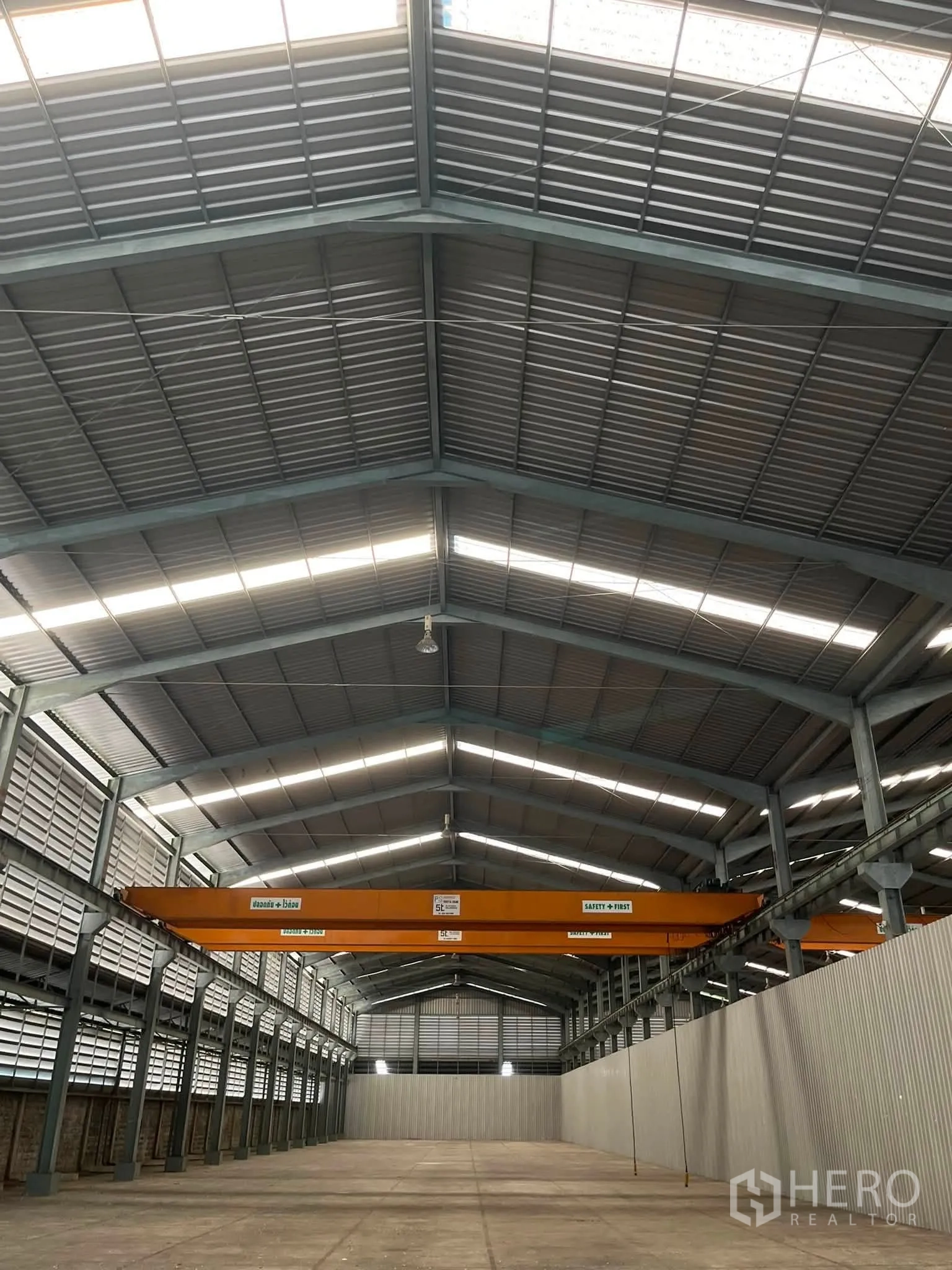 Warehouse for rent in Bang Phli, Samut Prakan - Wide warehouse span with overhead cranes and illuminated roof panels.
