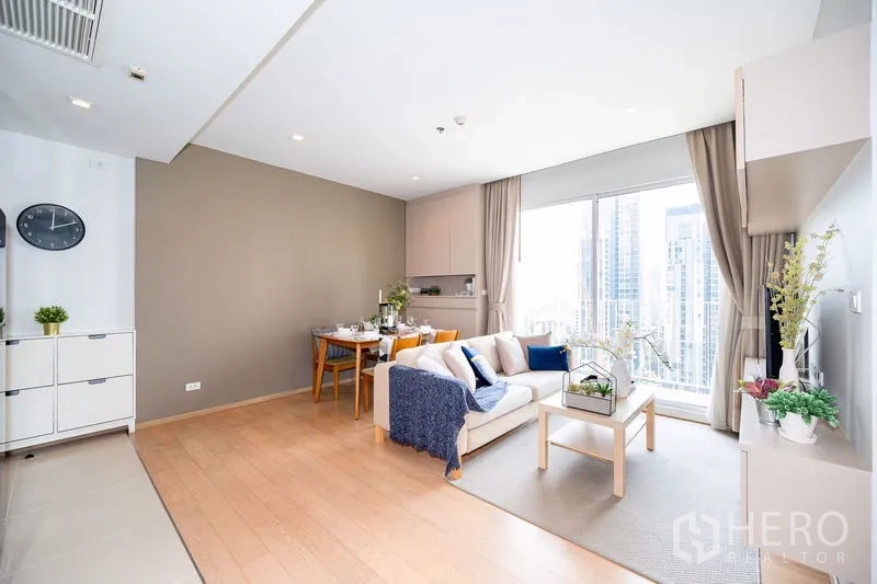 公寓 出租在Watthana, Bangkok - 客厅配沙发、餐桌与整面高窗，采光充足。