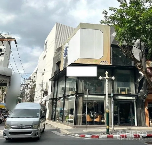 店屋 出租在Watthana, Bangkok - 瓦他那区澎蓬片区转角店屋，双层挑高玻璃立面与大型看板。