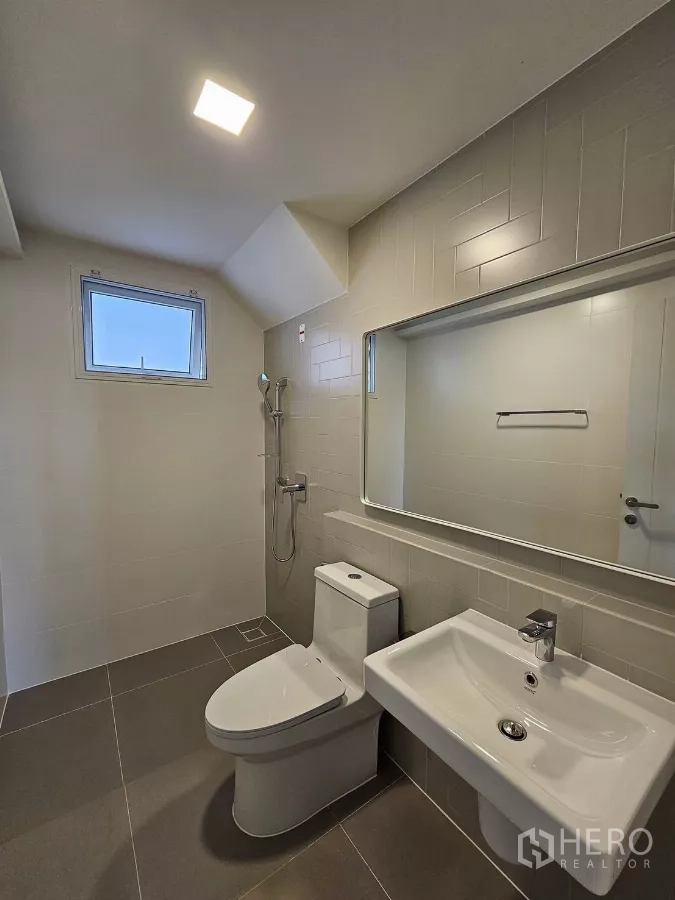Detached House for rent in Bang Phli, Samut Prakan - Modern bathroom with shower, toilet, vanity and large mirror.