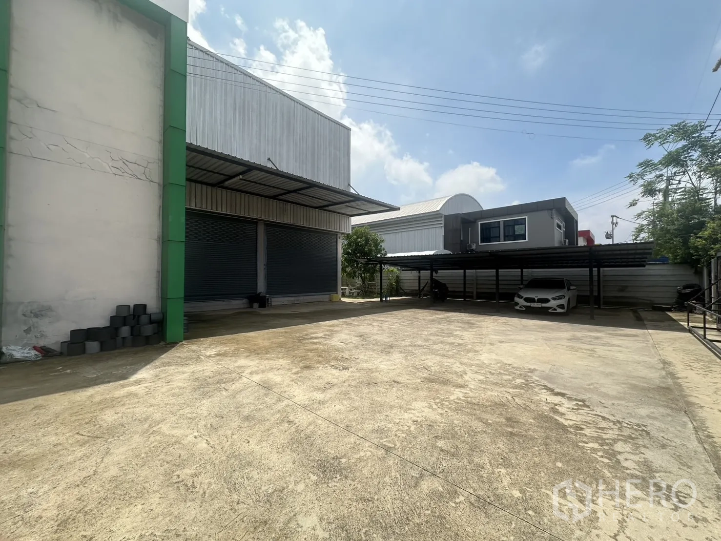 Warehouse for sale in Bang Len, Nakhon Pathom - Spacious concrete yard with loading bays and shaded car parking.