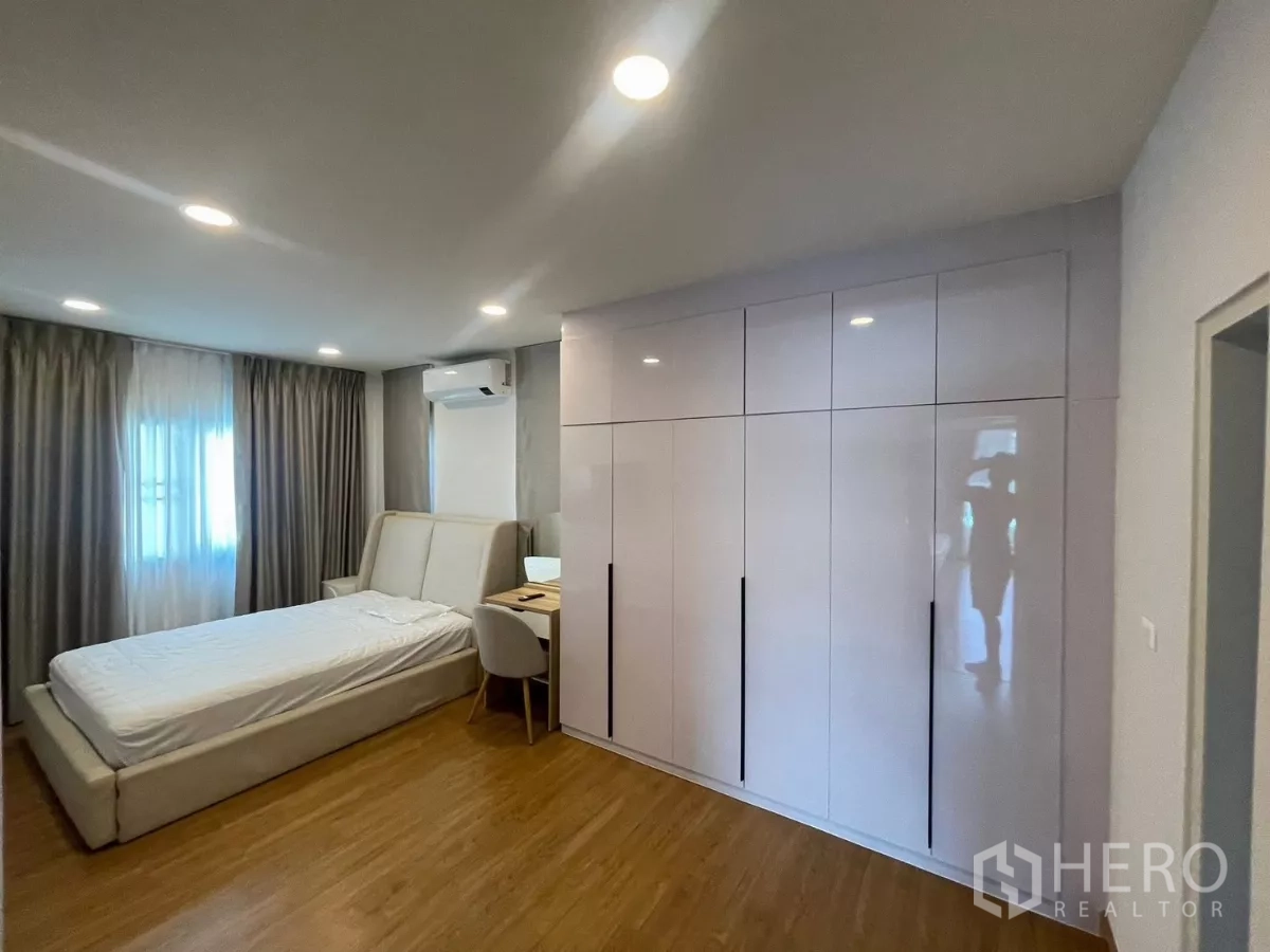独立式住宅 出租在Bang Phli, Samut Prakan - 次卧带高光定制衣柜、书桌与空调。