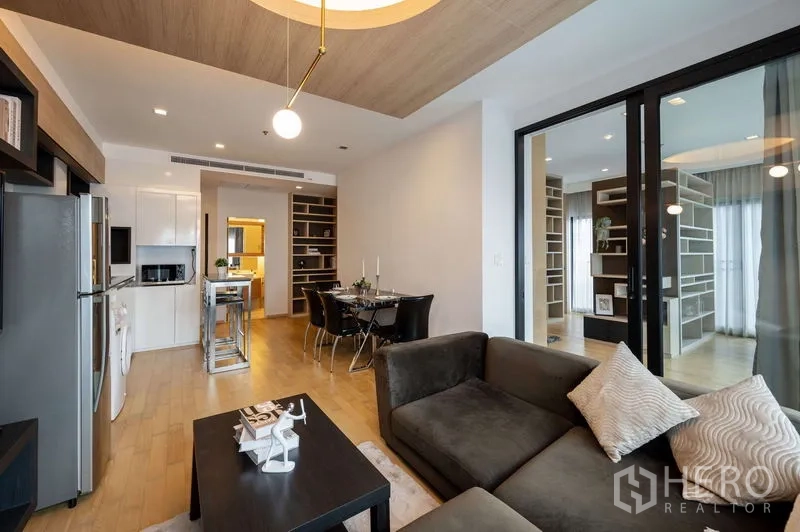 คอนโด ขายในWatthana, Bangkok - ห้องนั่งเล่นมีโซฟาตัวแอล โต๊ะกลาง และโคมไฟ แขวน มองไปยังครัวและมุมทานอาหาร