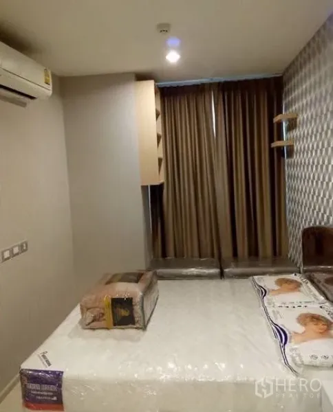 คอนโด ให้เช่าในKhlong Toei, Bangkok - ห้องนอนตกแต่งพร้อมเตียงขนาดใหญ่ ผนังลายแพดดิ้ง ผ้าม่านทึบ และเครื่องปรับอากาศติดผนัง