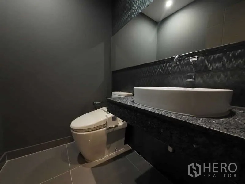 联排别墅 出租或出售在Lat Phrao, Bangkok - 深色调化妆间，智能马桶与台上盆石质台面。