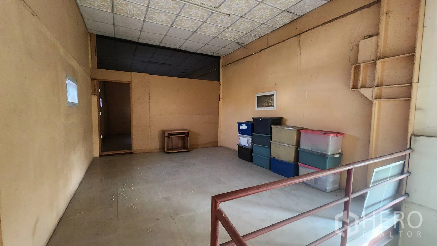 货栈 出租在Nonthaburi - 夹层储物区，设护栏与塑料周转箱。