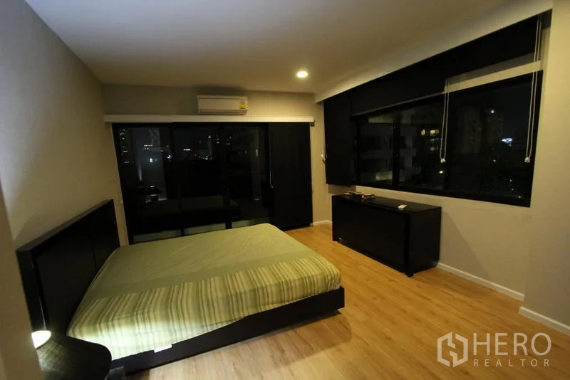 公寓 出租在Pathum Wan, Bangkok - 第二卧室设大窗，可见夜景并配遮光百叶。