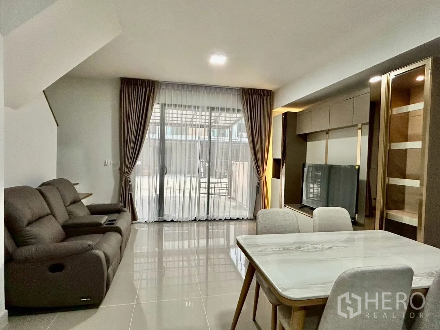 Townhouse for rent in Bang Phli, Samut Prakan - Living area facing sliding glass doors and built-in TV cabinet.