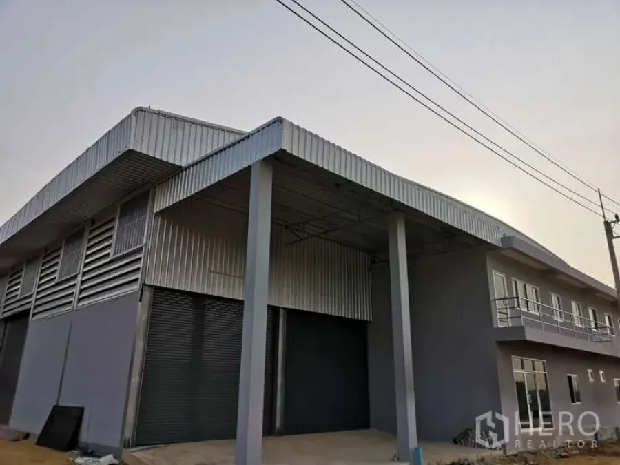 货栈 出租在Khlong Luang, Pathum Thani - 街景角度的仓库立面，带雨棚与双卷闸门。