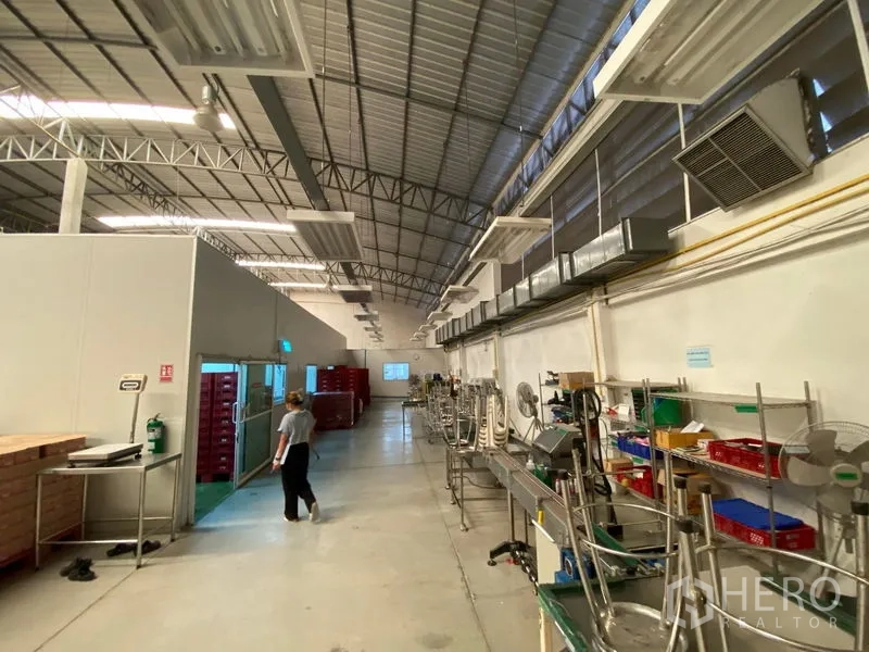 Warehouse for rent in Bueng Kum, Bangkok - Processing zone showing ventilation ducts, insulated doors and workbenches inside a large warehouse.
