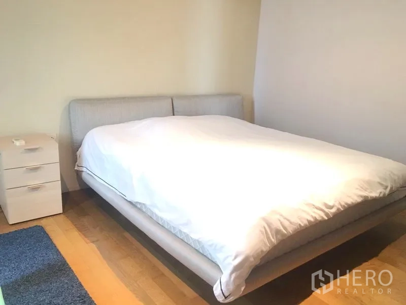 คอนโด ให้เช่าในWatthana, Bangkok - ห้องนอนหลักเตียงคู่ โต๊ะข้างเตียง พื้นไม้โทนอบอุ่น