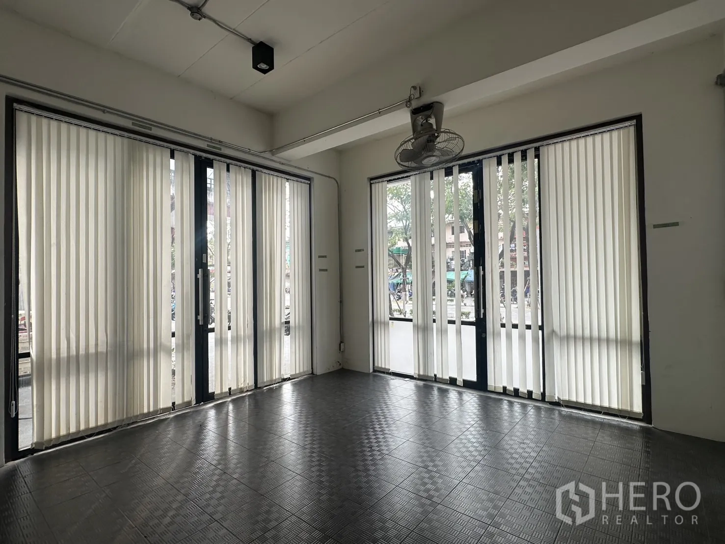 带办公室的家 for rent in Pathum Wan, Bangkok - 大型开放大厅，多组玻璃门、吊扇与深色网格地砖。