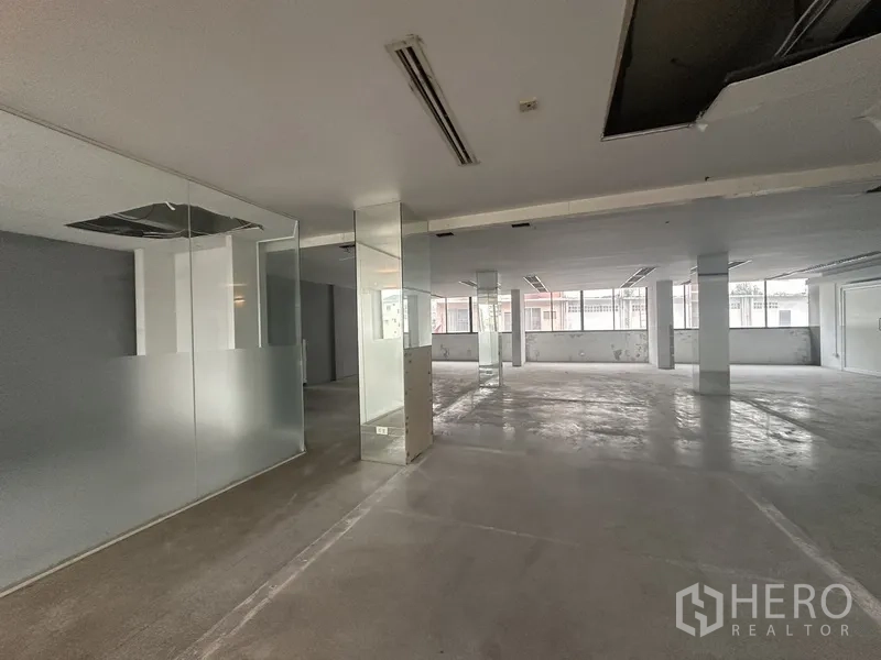 Office Space for rent in Khlong Toei, Bangkok - Expansive office floor with frosted glass partitions, columns and street-facing windows.