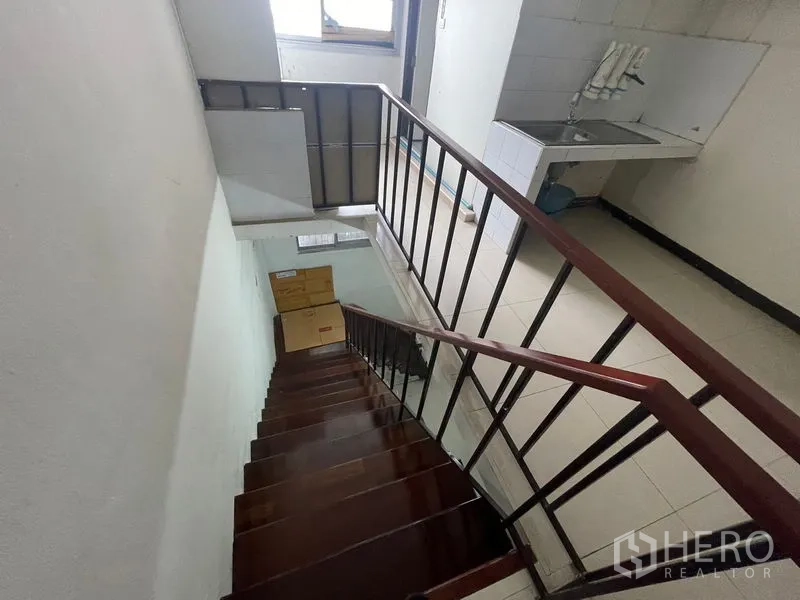 店屋 出租在Phra Khanong, Bangkok - 楼梯间俯视至平台，旁有功能水槽与窗户。