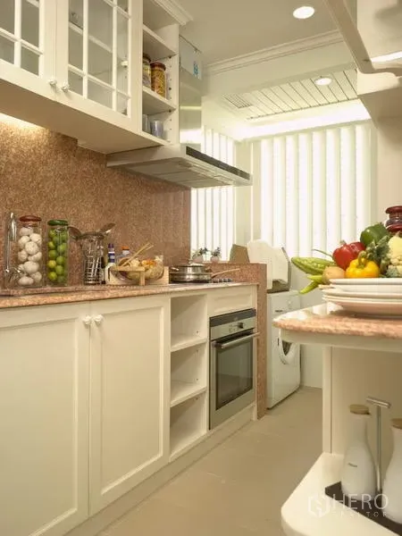 Apartment for rent in Bang Rak, Bangkok - Compact galley kitchen with white cabinets, stone countertops, oven, range hood and washer by vertical blinds.