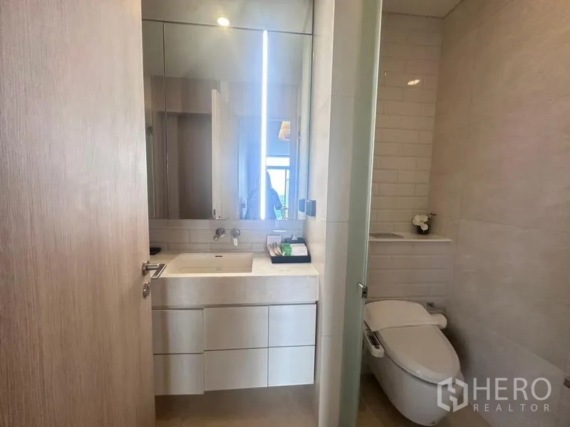 คอนโด ให้เช่า - ห้องน้ำสมัยใหม่ เคาน์เตอร์อ่างล้างหน้า กระจกบานใหญ่ และโถสุขภัณฑ์อัตโนมัติ