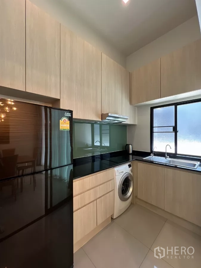 ทาวน์เฮาส์ ให้เช่าในSuan Luang, Bangkok - ครัวรูปตัว U ตู้ไม้ ท็อปสีดำ พร้อมเครื่องใช้ไฟฟ้าและเครื่องซักผ้า