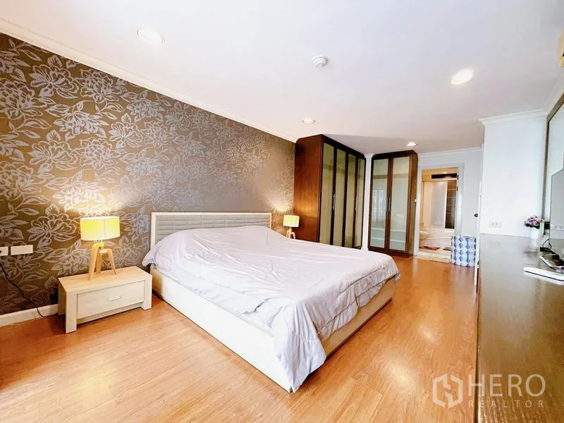 公寓 出租在Watthana, Bangkok - 主卧配大床，花纹背景墙与内置衣柜。