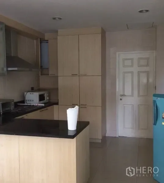 Detached House for rent in Bang Phli, Samut Prakan - Fitted kitchen with light wood cabinetry, black granite countertop, hob and extractor.