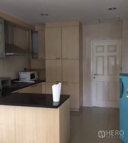 Detached House for rent in Bang Phli, Samut Prakan - Fitted kitchen with light wood cabinetry, black granite countertop, hob and extractor.