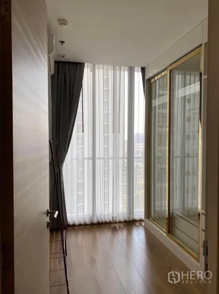 Condominium for rent in Khlong Toei, Bangkok - Dressing room or small bedroom with balcony access, glass-front wardrobe, and floor-to-ceiling windows.