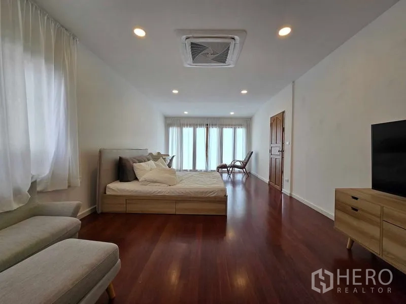 สำนักงานที่บ้าน ให้เช่า - ห้องนอนขนาดใหญ่ พื้นไม้ มีชั้นวางทีวี และประตูกระจกเต็มบาน