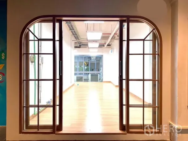 Office Space for rent in Khlong Toei, Bangkok - Arched glass sliding doors opening to a bright wood‑floored office.