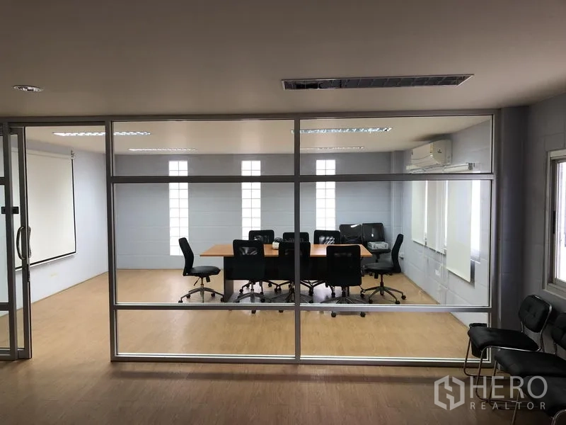 Factory for sale in Pathum Thani - Glass‑partitioned conference room viewed from the corridor.