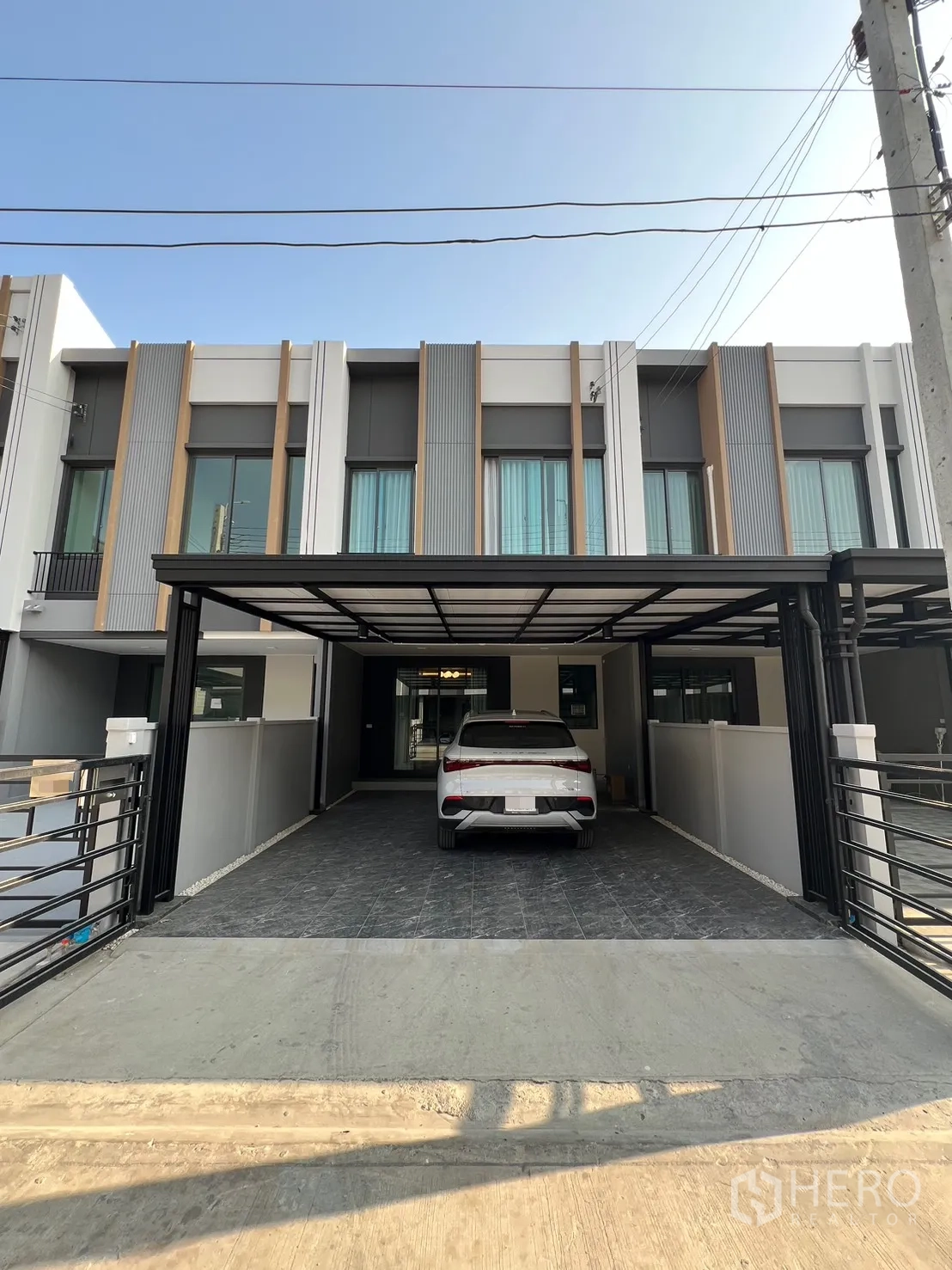 Townhouse for rent in Bang Phli, Samut Prakan - Contemporary townhouse exterior with a covered carport and gated entrance.