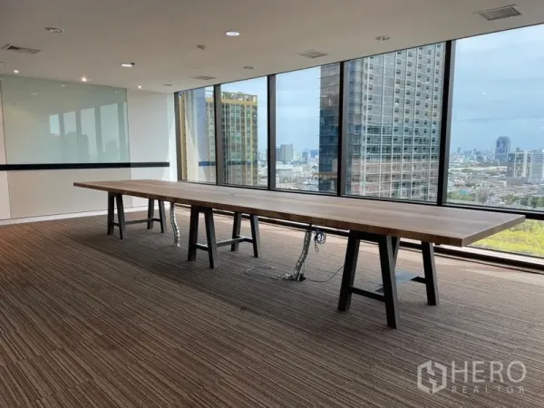 Office Space for rent - High-floor boardroom with a long meeting table and floor-to-ceiling windows overlooking the Bangkok skyline.