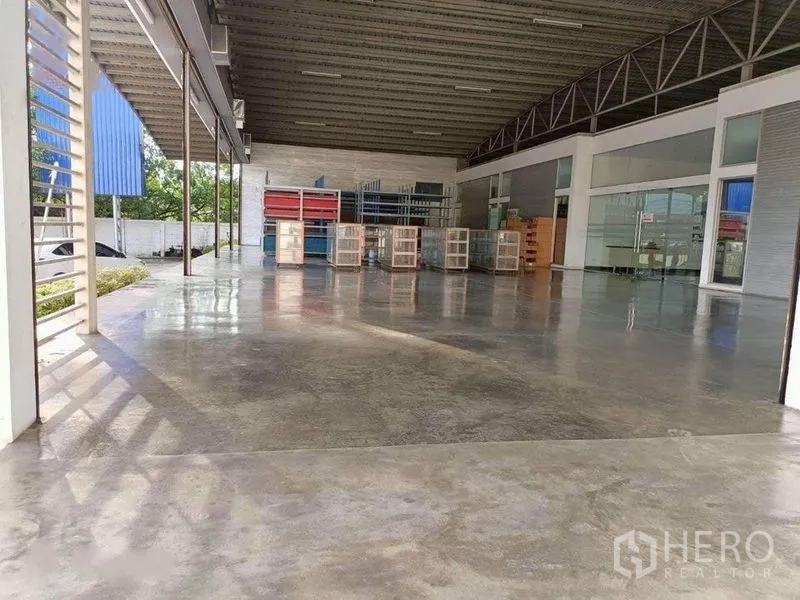 Warehouse for rent in Bang Phli, Samut Prakan - Open warehouse platform featuring polished concrete floor, glass-fronted office wall, and steel roof trusses.