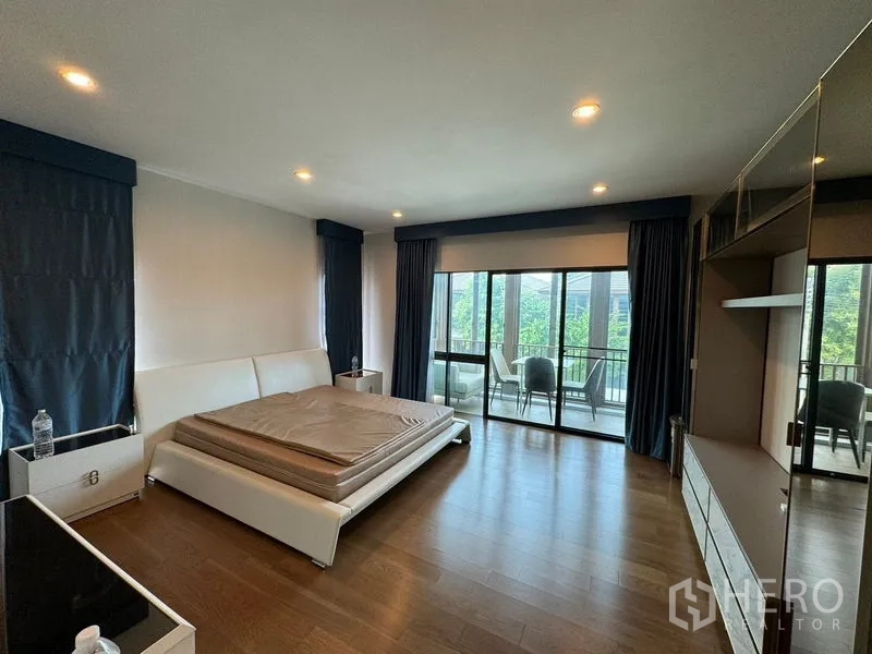 Detached House for rent in Prawet, Bangkok - Spacious master bedroom with balcony access and floor-to-ceiling windows.