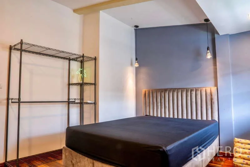 联排别墅 出租在Khlong Toei, Bangkok - 卧室配软包床头、吊灯与开放式金属置物架