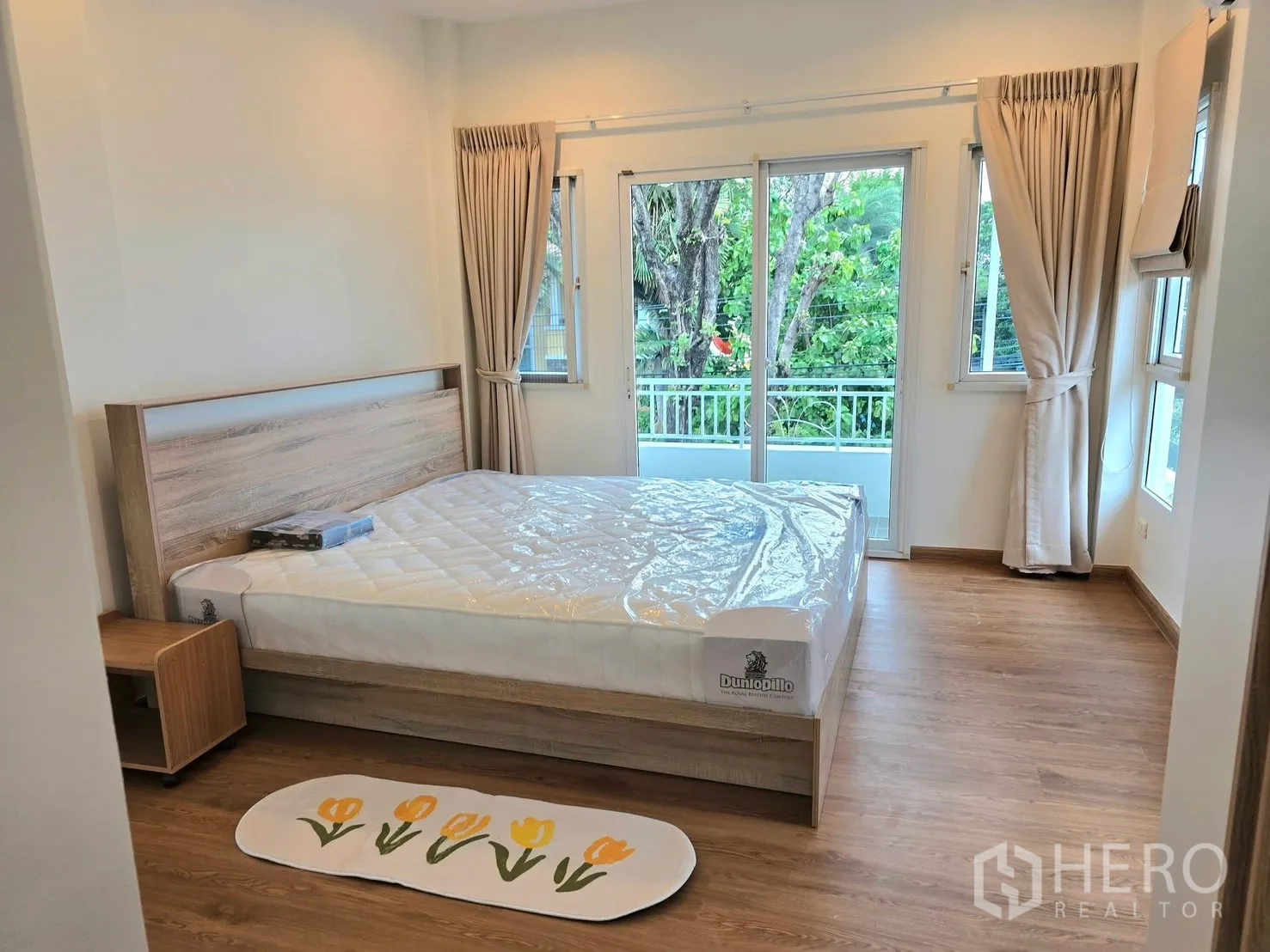 独栋房屋 for rent in Bang Phli, Samut Prakan - 明亮卧室，双人床、阳台玻璃门与木地板。